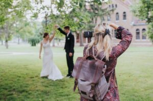 wedding photographer taking photo of married couple